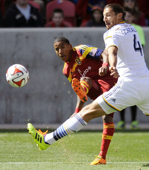Real Salt Lake forward Joao Plata (8) kicks the ball around the defense of Los Angeles Galaxy defender Omar Gonzalez (4) during a game at Rio Tinto Stadium on Saturday, March 22, 2014.