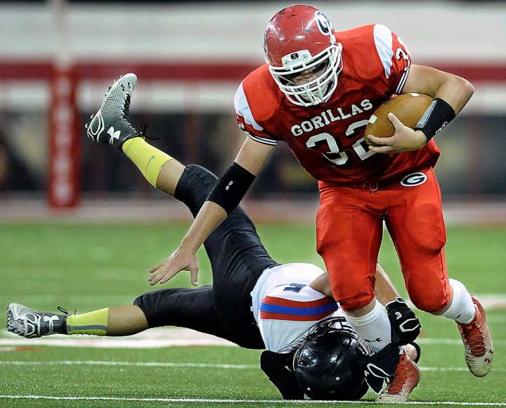 Gregory's Jonah Beck (32) tries to slip out of the tackle of Woonsocket/Wessington Springs/Sanborn Central's Austin Messmer (5) during the 9AA state championship game on Thursday at the DakotaDome in Vermillion. (Matt Gade/Republic)