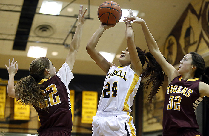 Mitchell's Taylor Volesky (24) shoots between the defense of Harrisburg's Haley Bruggeman (22) and Harrisburg's Sam Slaughter (32) during a game Tuesday night at the Corn Palace. (Matt Gade/Republic)