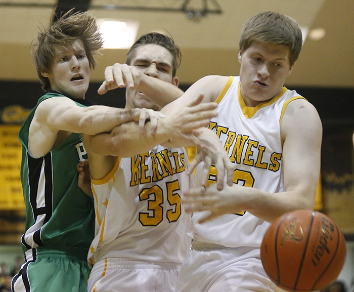 Mitchell High School's Mitchell's Kanin Nelson (35) and Mitchell's Alex Hartman (52) fight with  a Pierre T. F. Riggs' defender for a loose a ball during a game on Friday night at the Corn Palace in Mitchell. (Matt Gade/Republic)