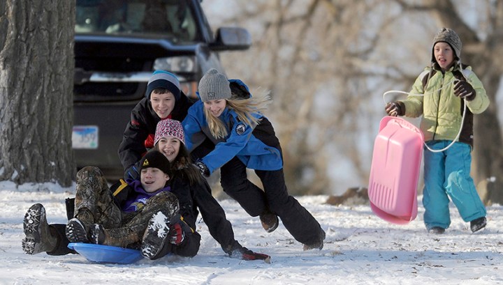 Mckenzie Endorf (13) and Alex Kuck (13) get a push from Grace (12) and Tristan Endorf (13) down the hill as 10-year-old Anna Endorf looks on while sledding on a hill next to Lake Mitchell on Friday afternoon in Mitchell. (Matt Gade/Republic)